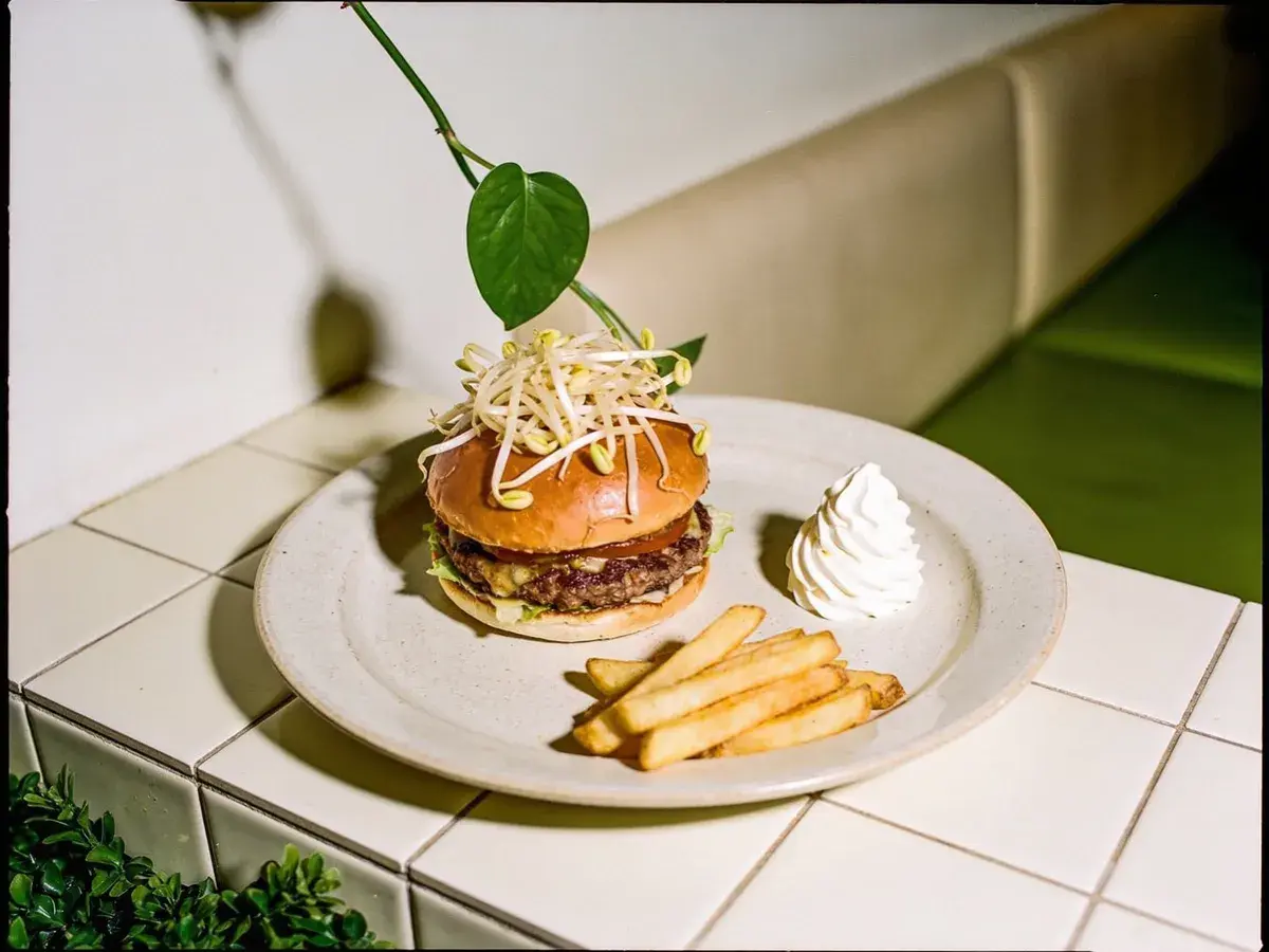 Editorial illustration: BUN BUN BURGERS SOFT-OPENS AT LEONA BOTANICAL CAFE IN SUNSET VALLEY