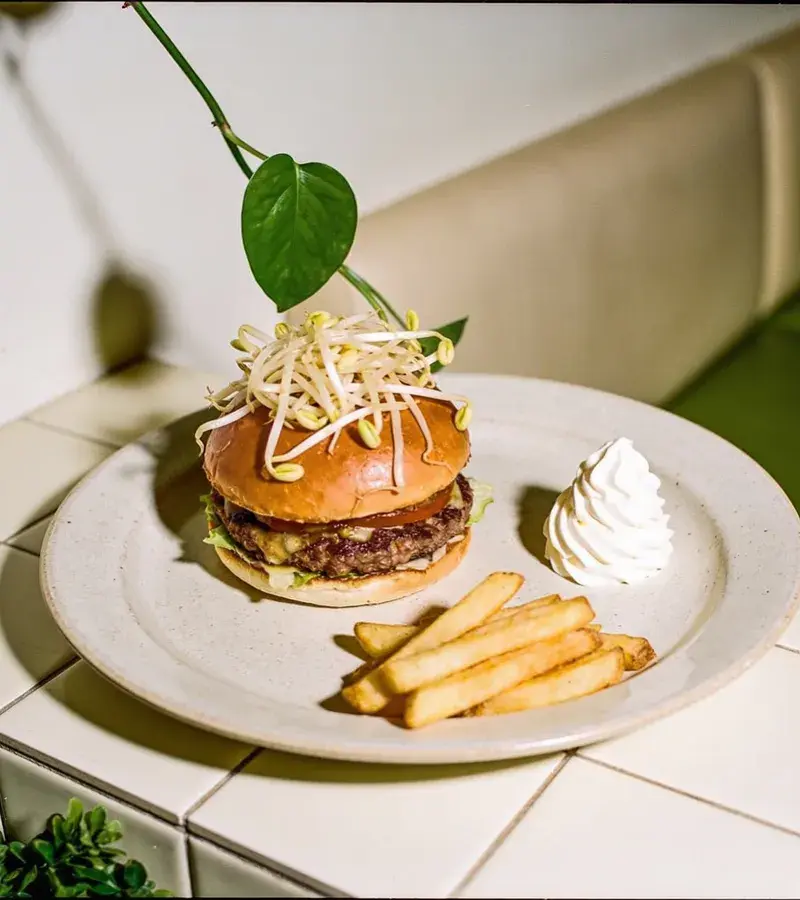 Editorial illustration: BUN BUN BURGERS SOFT-OPENS AT LEONA BOTANICAL CAFE IN SUNSET VALLEY